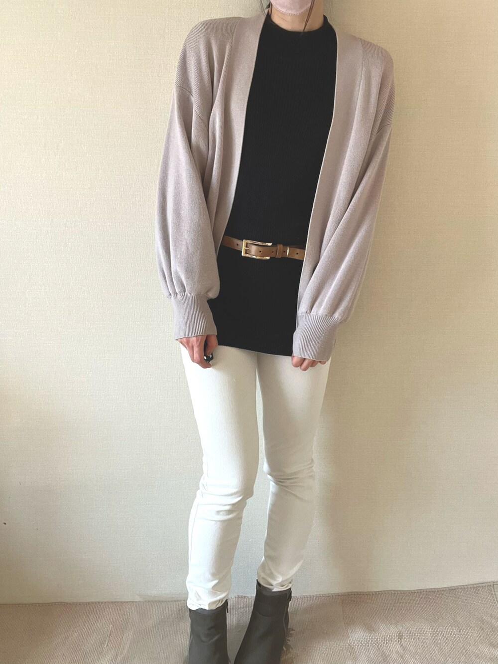 グレー系のブーツ、ブルー系のトートバッグ、ホワイト系のデニムパンツを着用したレディースの春コーディネートの2枚目の写真