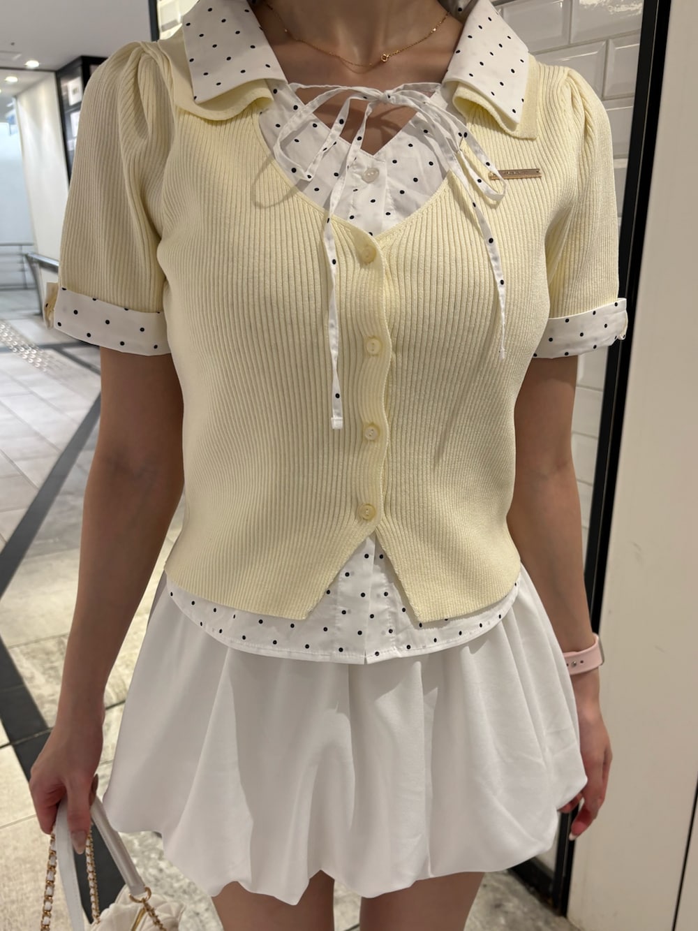 イエロー系のニット/セーター、ブラック系のニット/セーター、ブラック系のスカートを着用したレディースの夏コーディネートの5枚目の写真