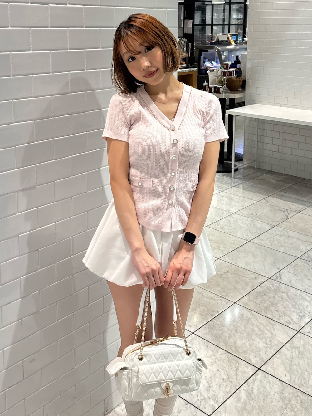ピンク系のニット/セーター、ホワイト系のスカート、ホワイト系のサンダルを着用したレディースの夏コーディネートの4枚目の写真