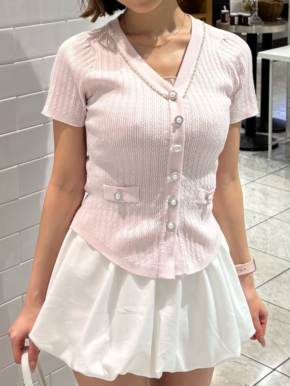 ピンク系のニット/セーター、ホワイト系のスカート、ホワイト系のサンダルを着用したレディースの夏コーディネートの5枚目の写真