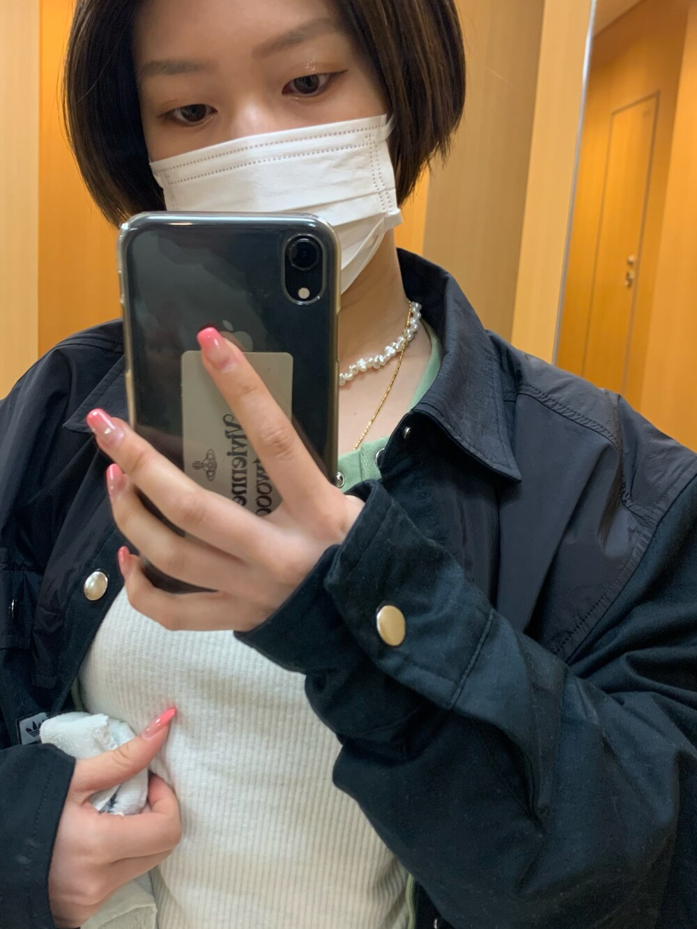 ホワイト系のTシャツ/カットソー、グリーン系のカーディガン/ボレロ、ブルー系のデニムパンツを着用したレディースの春コーディネートの2枚目の写真