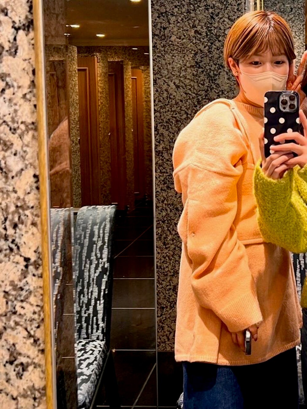 ピンク系のニット/セーター、ブルー系のデニムパンツ、ブラック系のブーツを着用したレディースの冬コーディネートの2枚目の写真