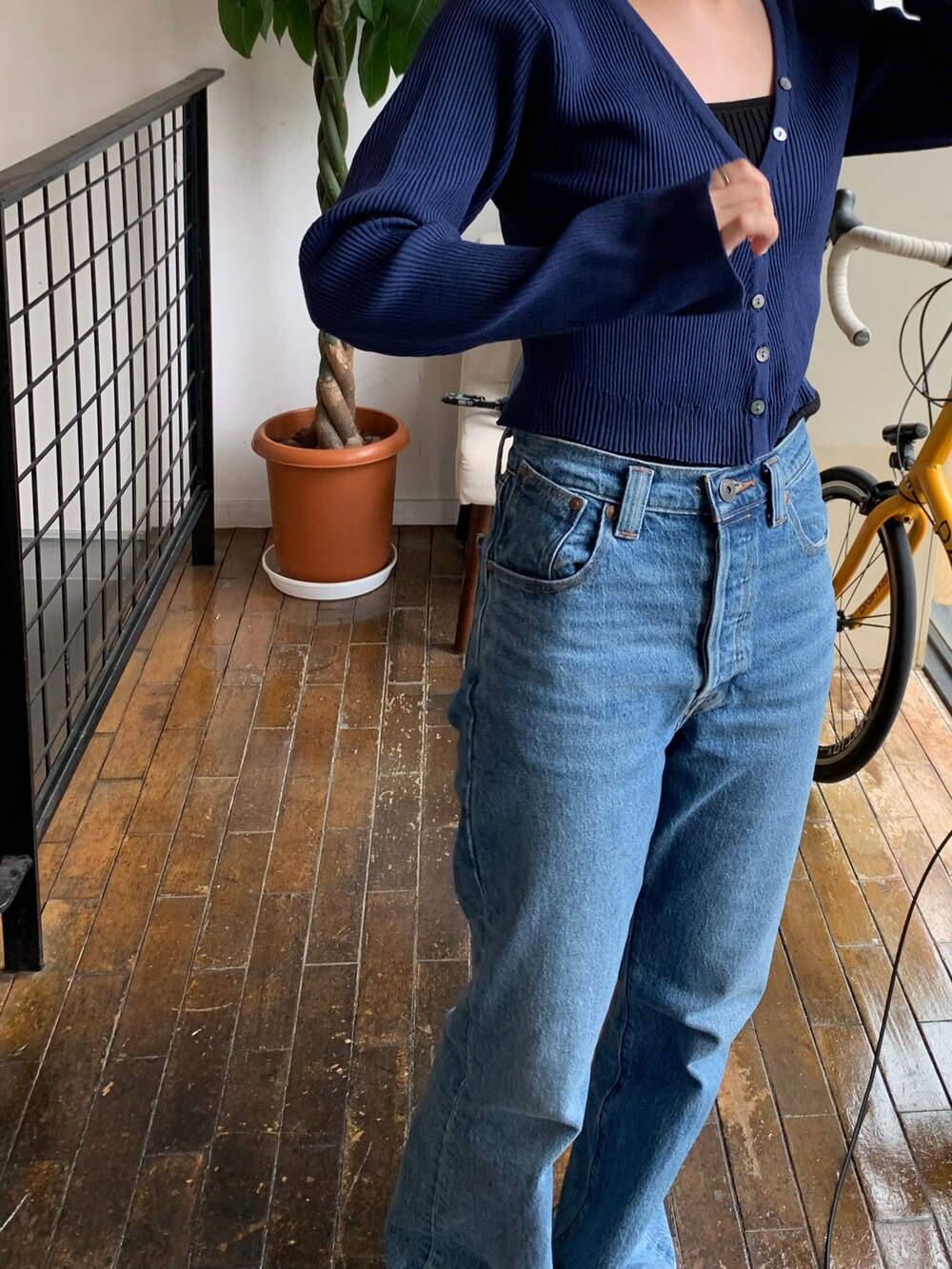 ブルー系のカーディガン/ボレロ、ブラック系のキャミソール、ブルー系のデニムパンツを着用したレディースの夏コーディネートの2枚目の写真