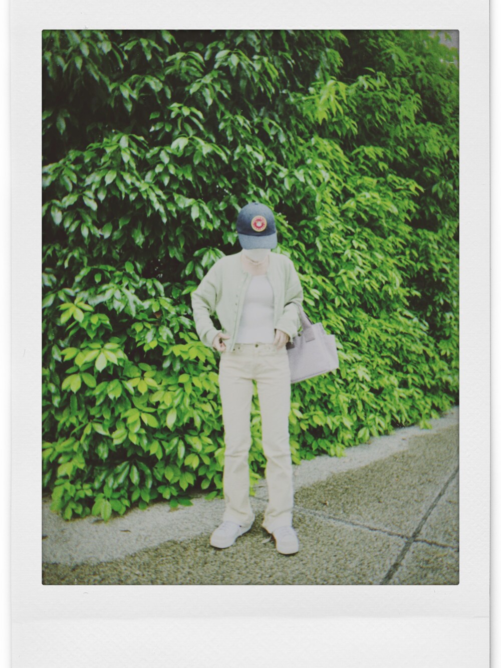 ホワイト系のキャミソール、グリーン系のカーディガン/ボレロ、イエロー系のパンツを着用したレディースの春コーディネートの2枚目の写真