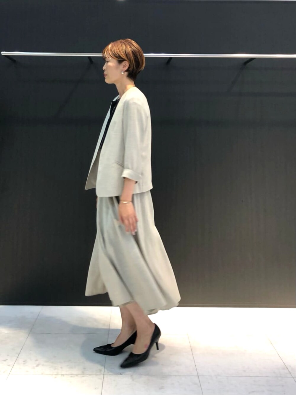 ホワイト系のスカート、ブラック系のトップスを着用したレディースの春コーディネートの3枚目の写真