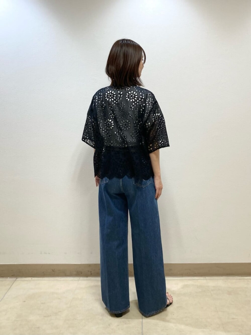 ブルー系のデニムパンツ、ブラック系のシャツ/ブラウス、グレー系のサンダルを着用したレディースの春コーディネートの5枚目の写真