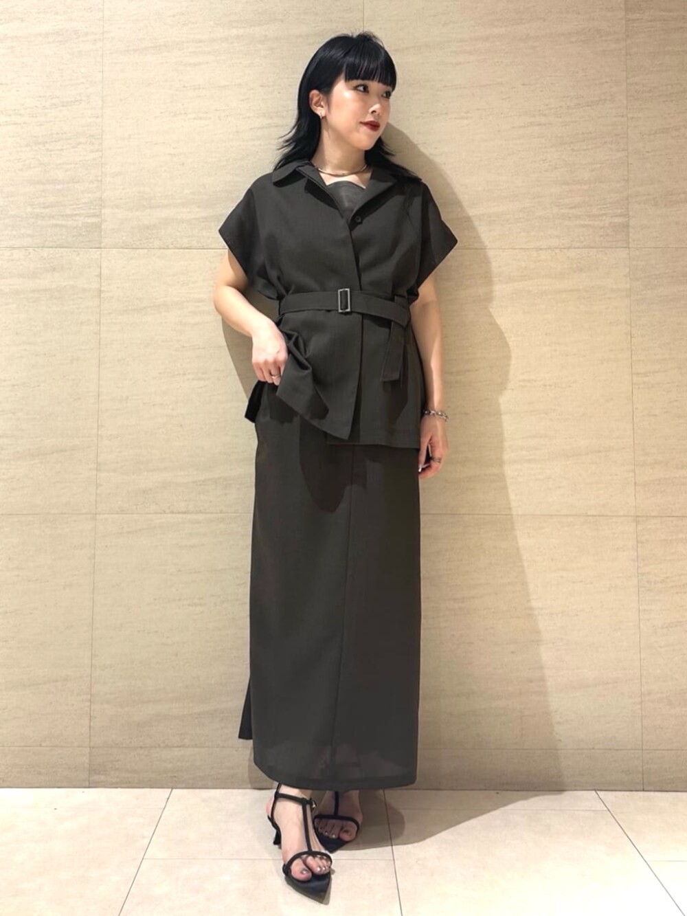 ブラウン系のベスト、ブラウン系のスカート、ブラウン系のキャミソールを着用したレディースの春コーディネートの3枚目の写真