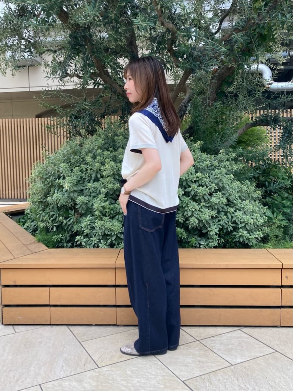 ブルー系のデニムパンツ、ホワイト系のニット/セーター、ブラック系のベルトを着用したレディースの夏コーディネートの3枚目の写真