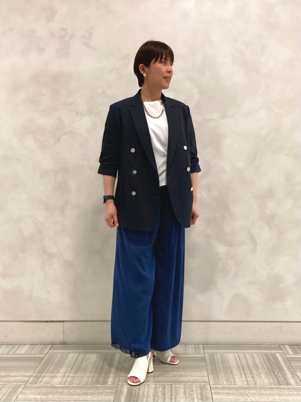 ホワイト系のサンダル、ホワイト系のTシャツ/カットソー、ブルー系のその他パンツを着用したレディースの夏コーディネートの3枚目の写真