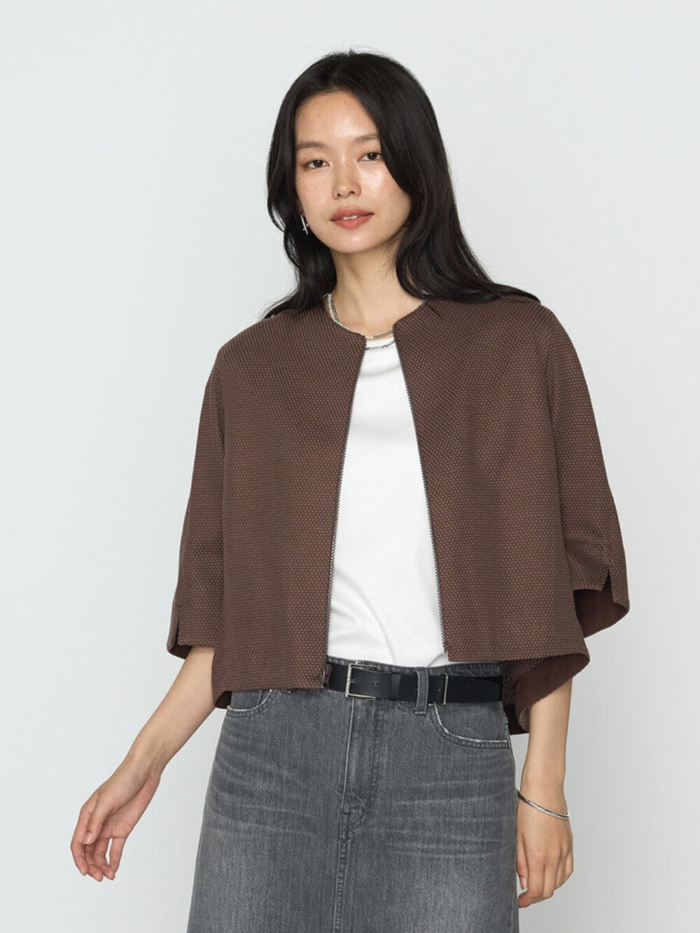 ブラウン系のブルゾン、グレー系のスカートを着用したレディースの春コーディネートの2枚目の写真