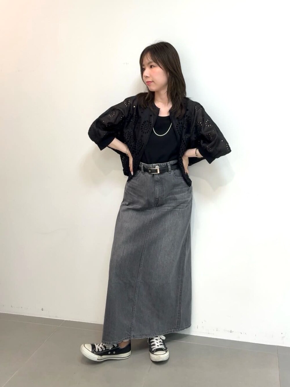 グレー系のスカート、ブラック系のタンクトップ、ブラック系のブルゾンを着用したレディースの夏コーディネートの2枚目の写真