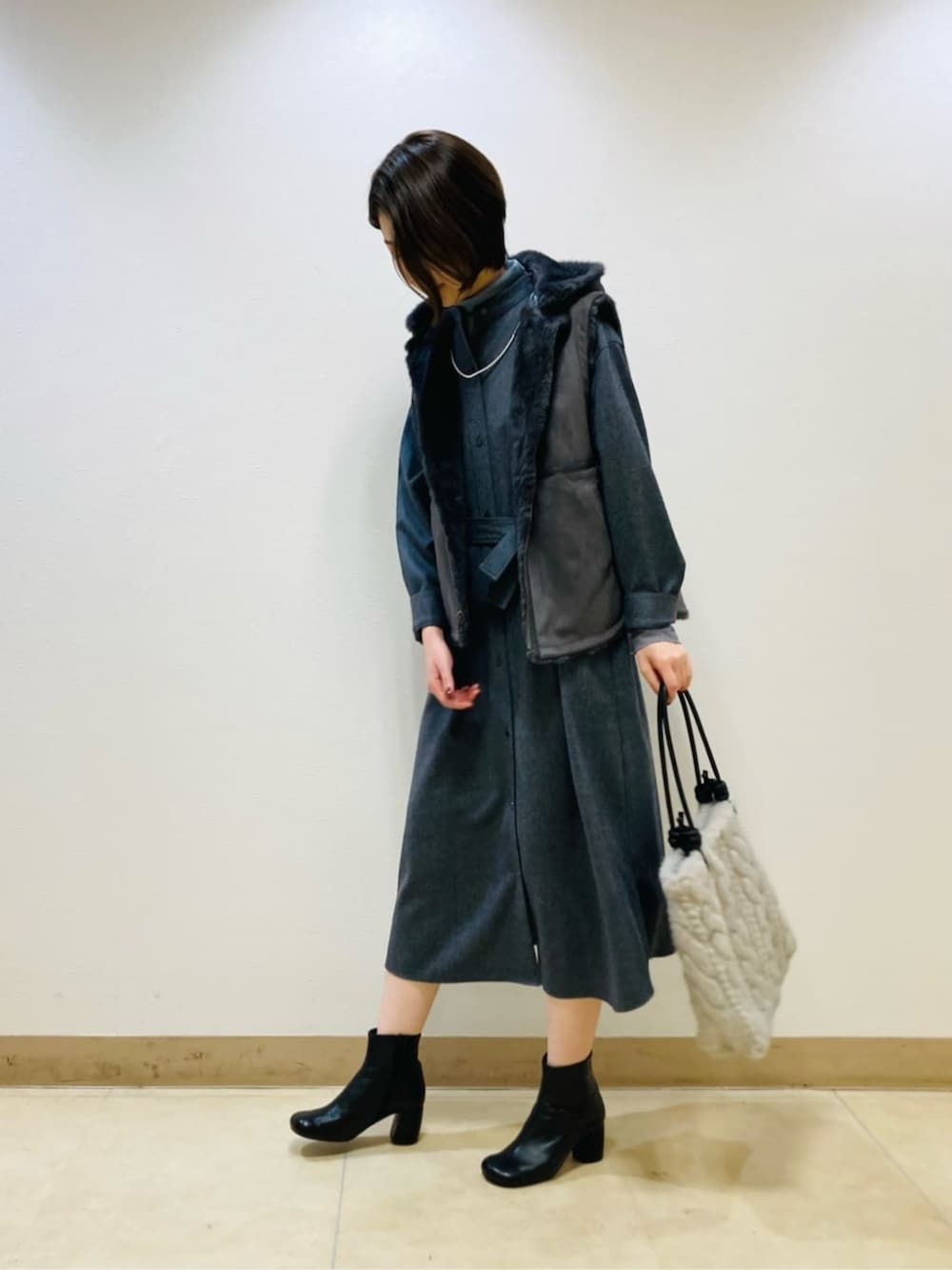 グレー系のベスト、グレー系のワンピースを着用したレディースの秋コーディネートの3枚目の写真