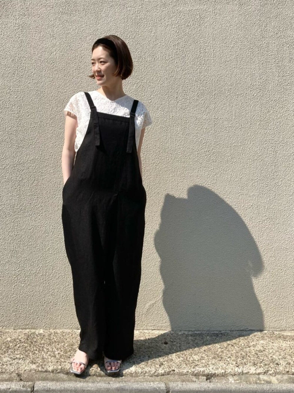 ホワイト系のシャツ/ブラウス、ブラック系のオールインワン・サロペットを着用したレディースの春コーディネートの2枚目の写真