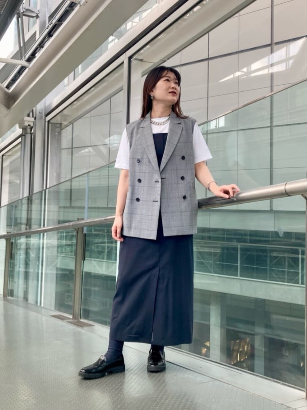 ブラック系のその他シューズ、ブラック系のベスト、ホワイト系のTシャツ/カットソーを着用したレディースの夏コーディネートの2枚目の写真