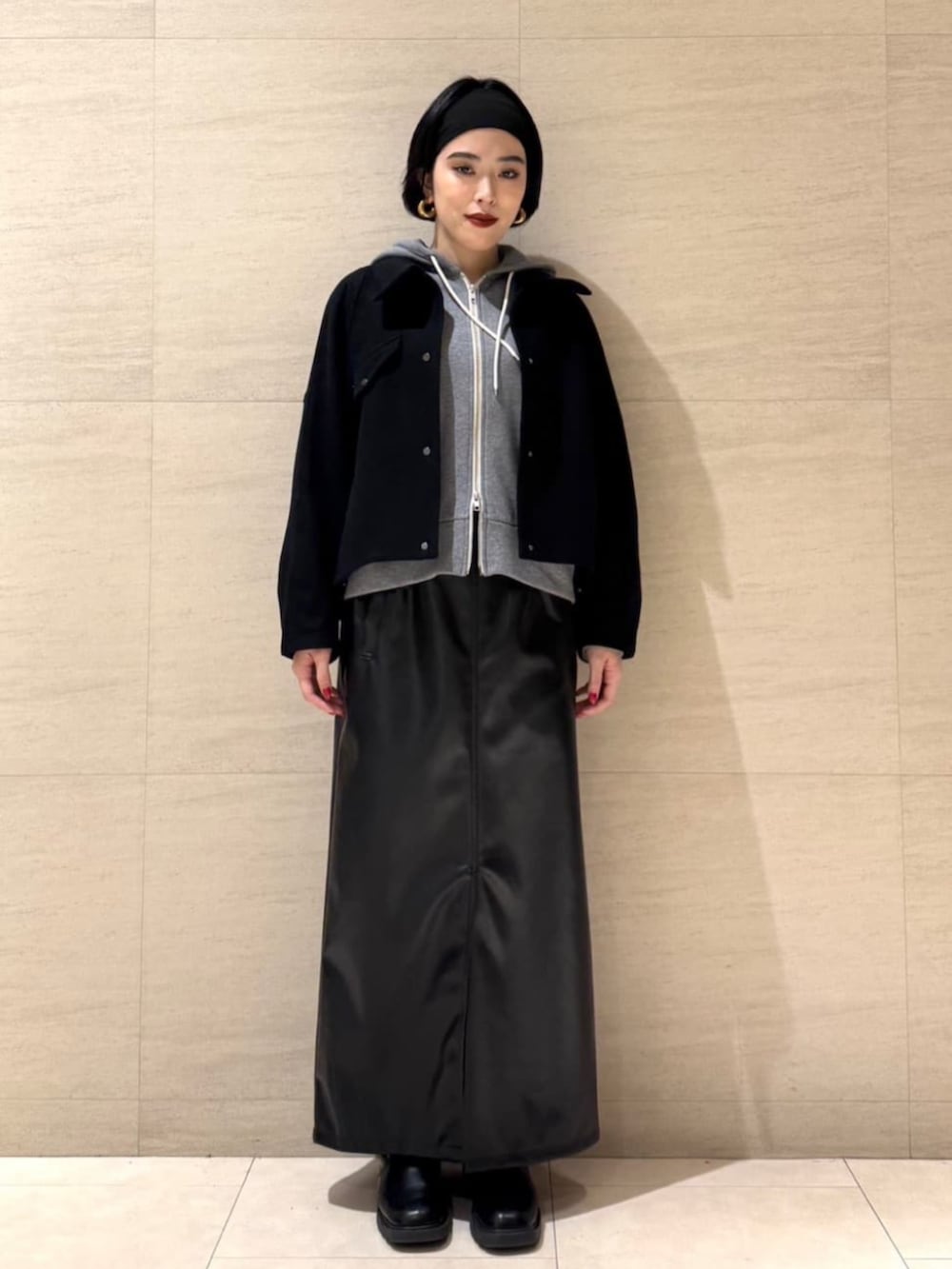 ブラック系のスカート、ブラック系のショルダーバッグ、ブラック系のブルゾンを着用したレディースの冬コーディネートの2枚目の写真