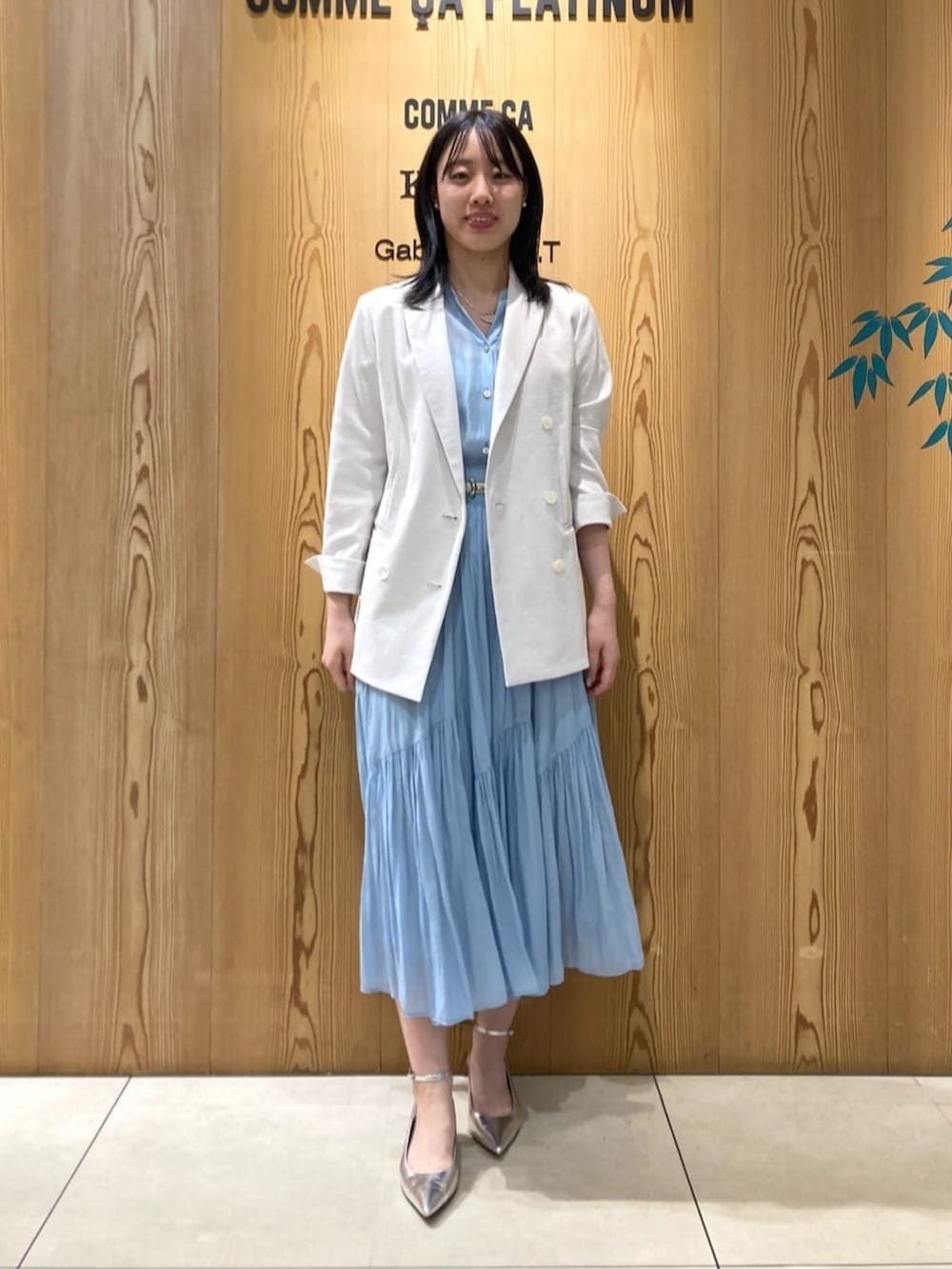 シルバー系のパンプス、ブルー系のスカート、ブルー系のシャツ/ブラウスを着用したレディースの春コーディネートの2枚目の写真