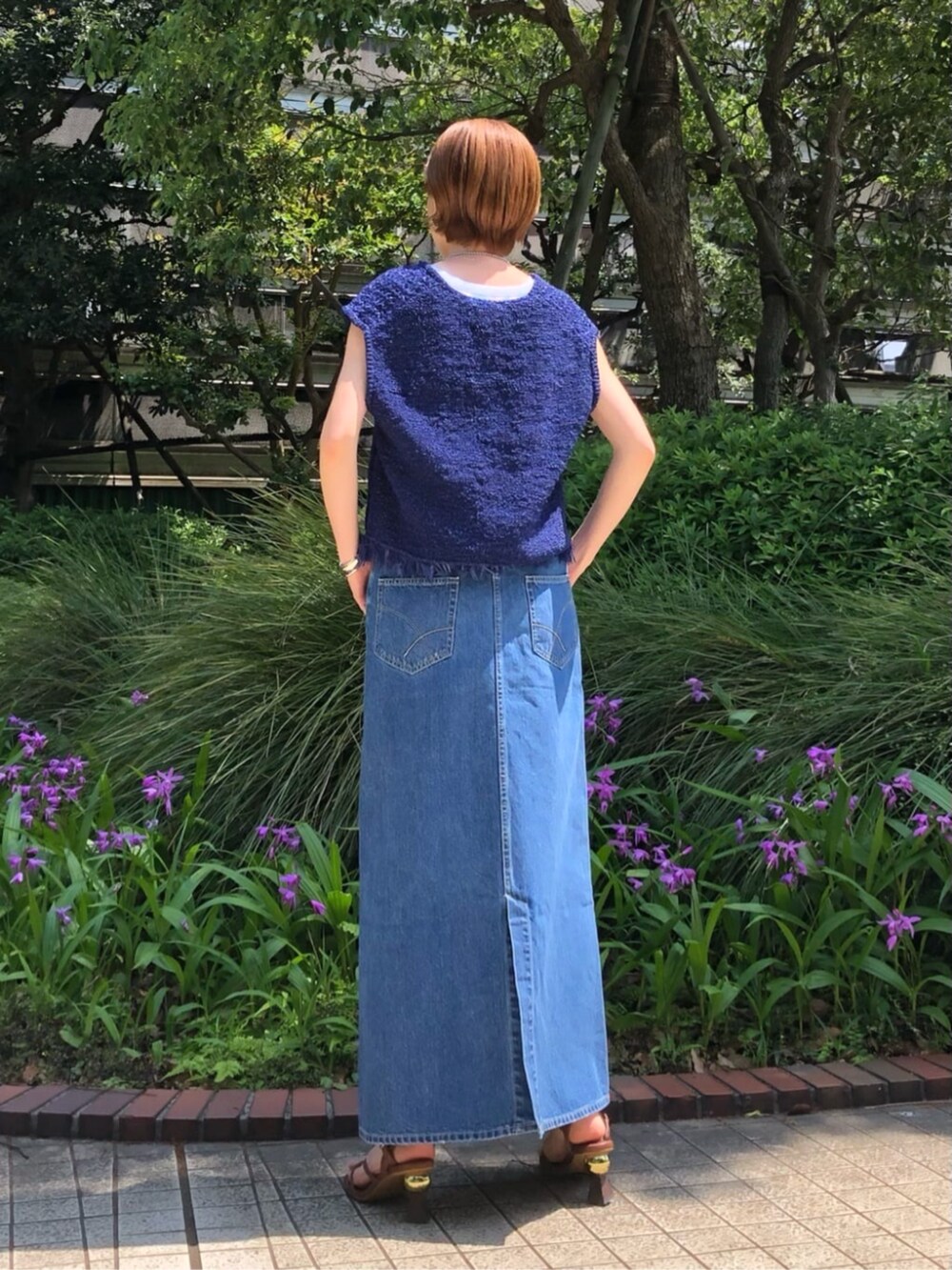 グレー系のスカート、ブルー系のニット/セーター、ブラウン系のベルトを着用したレディースの春コーディネートの4枚目の写真