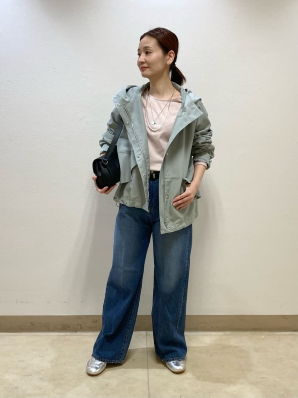 ブラック系のショルダーバッグ、グリーン系のパーカー、ピンク系のシャツ/ブラウスを着用したレディースの春コーディネートの2枚目の写真