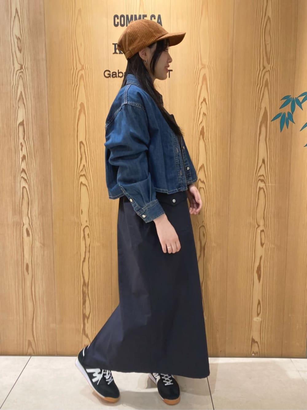 ブルー系のシャツ/ブラウス、ブルー系のジャンパースカート、イエロー系のキャップを着用したレディースの秋コーディネートの2枚目の写真