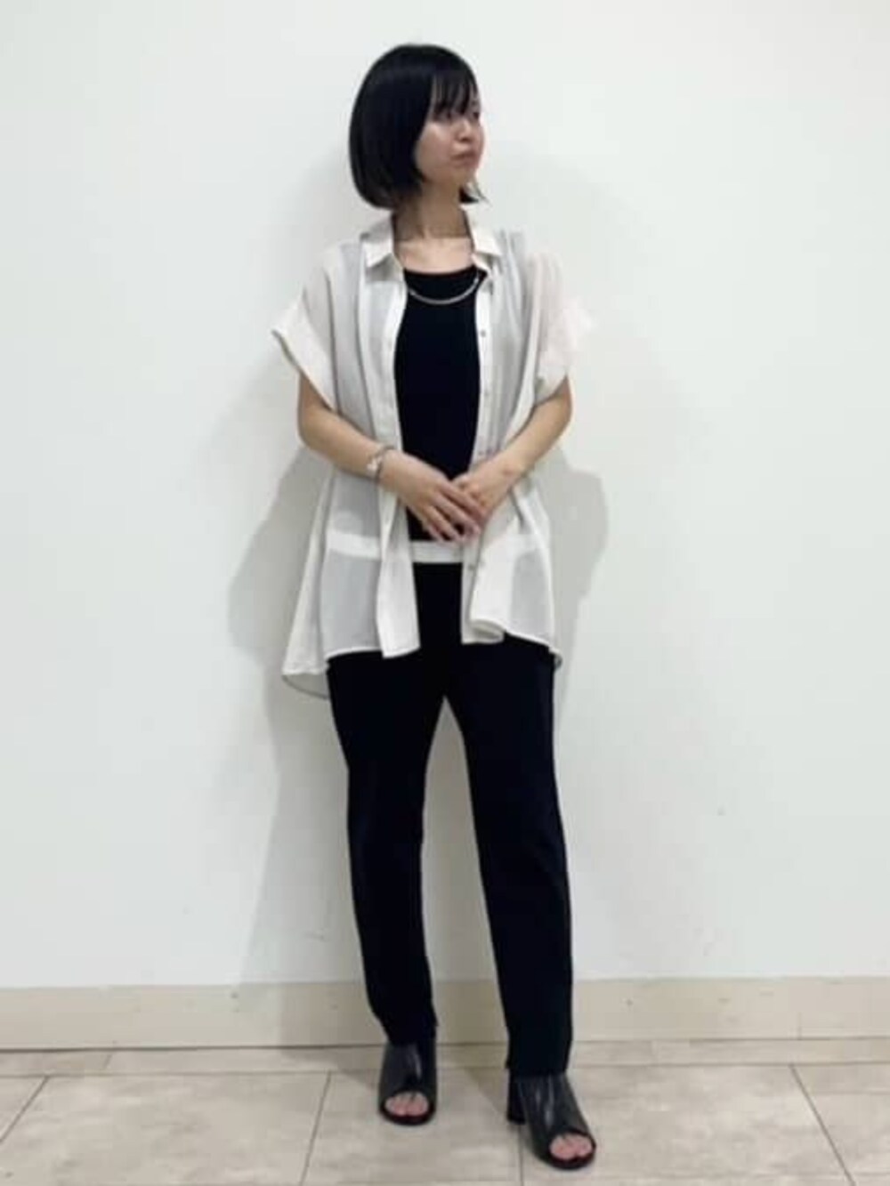 ブラック系のサンダル、ブラック系のその他パンツ、ホワイト系のシャツ/ブラウスを着用したレディースの夏コーディネートの2枚目の写真