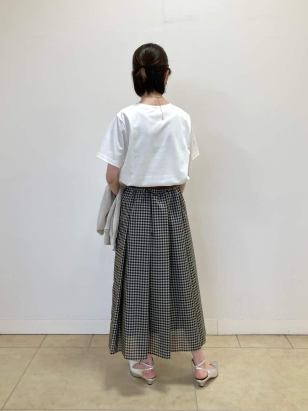 ベージュ系のカーディガン/ボレロ、ホワイト系のTシャツ/カットソー、ブラック系のスカートを着用したレディースの春コーディネートの6枚目の写真