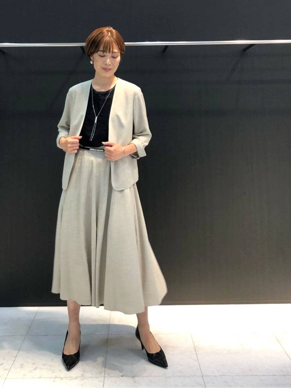 ホワイト系のスカート、ブラック系のトップスを着用したレディースの春コーディネートの2枚目の写真