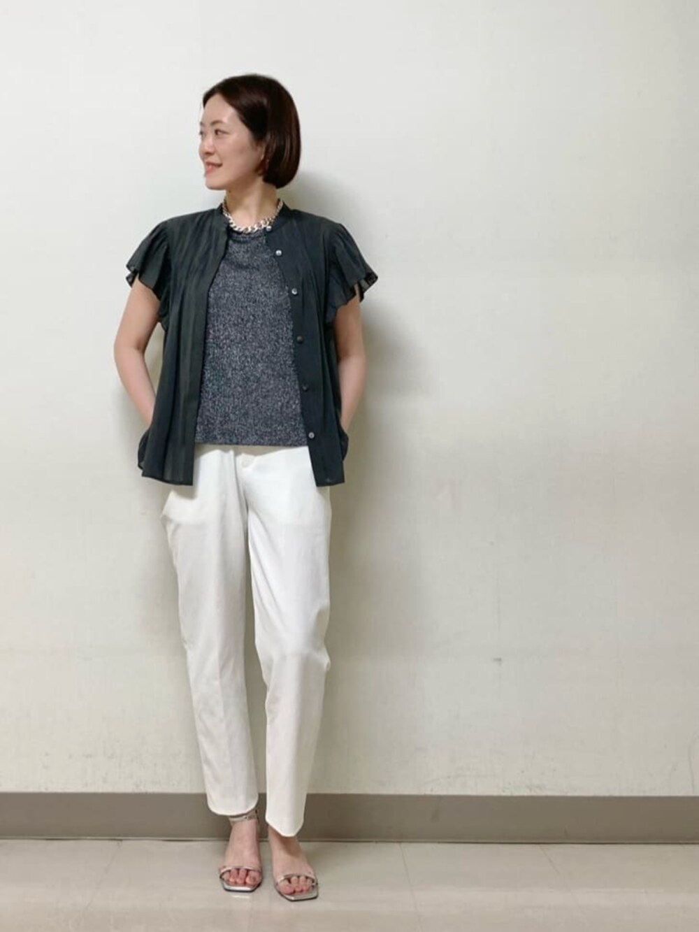 ベージュ系のカーディガン/ボレロ、グレー系のシャツ/ブラウス、ホワイト系のパンツを着用したレディースの夏コーディネートの6枚目の写真