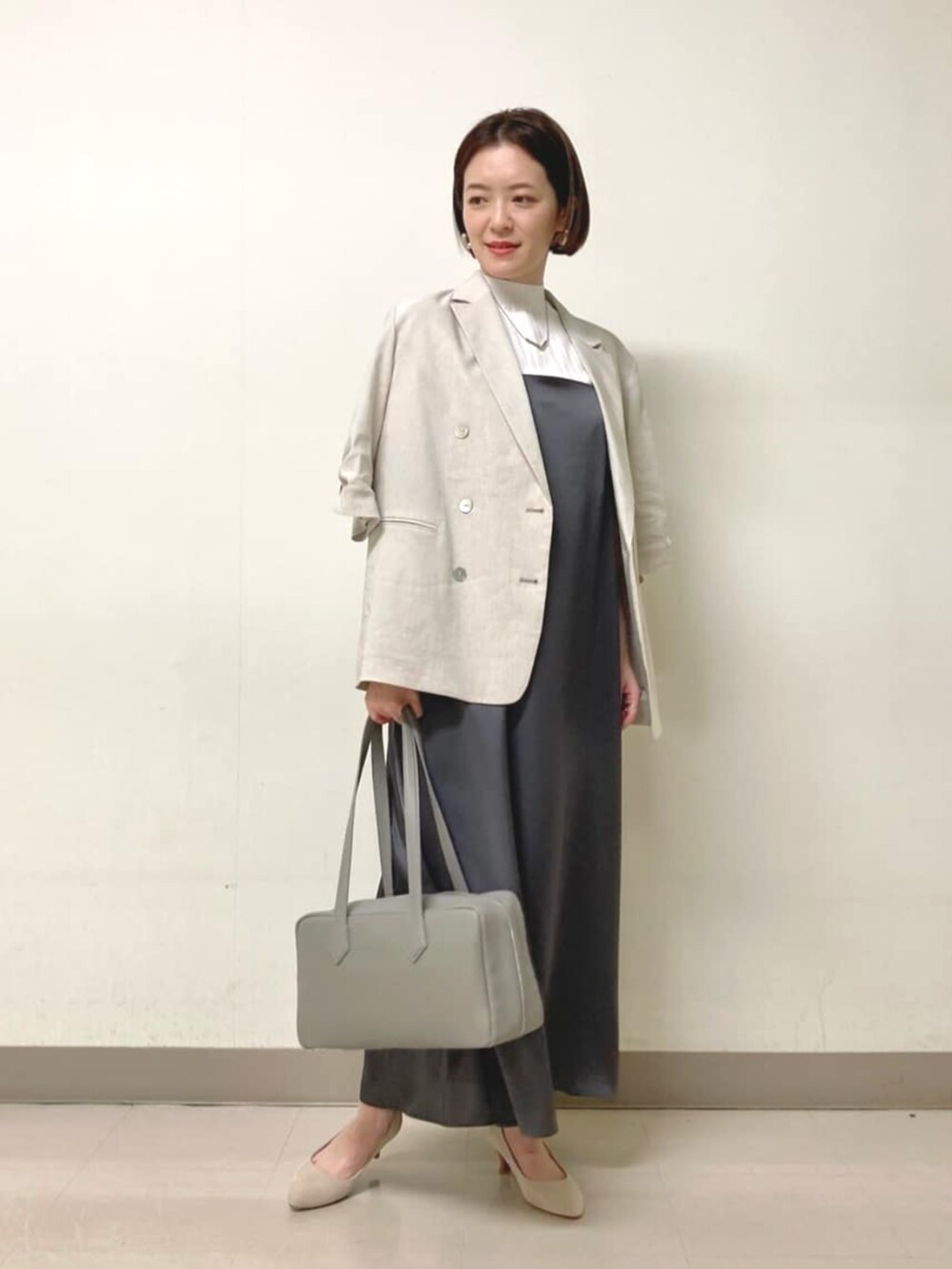 ホワイト系のニット/セーター、グレー系のテーラードジャケット、グレー系のワンピースを着用したレディースの春コーディネートの5枚目の写真