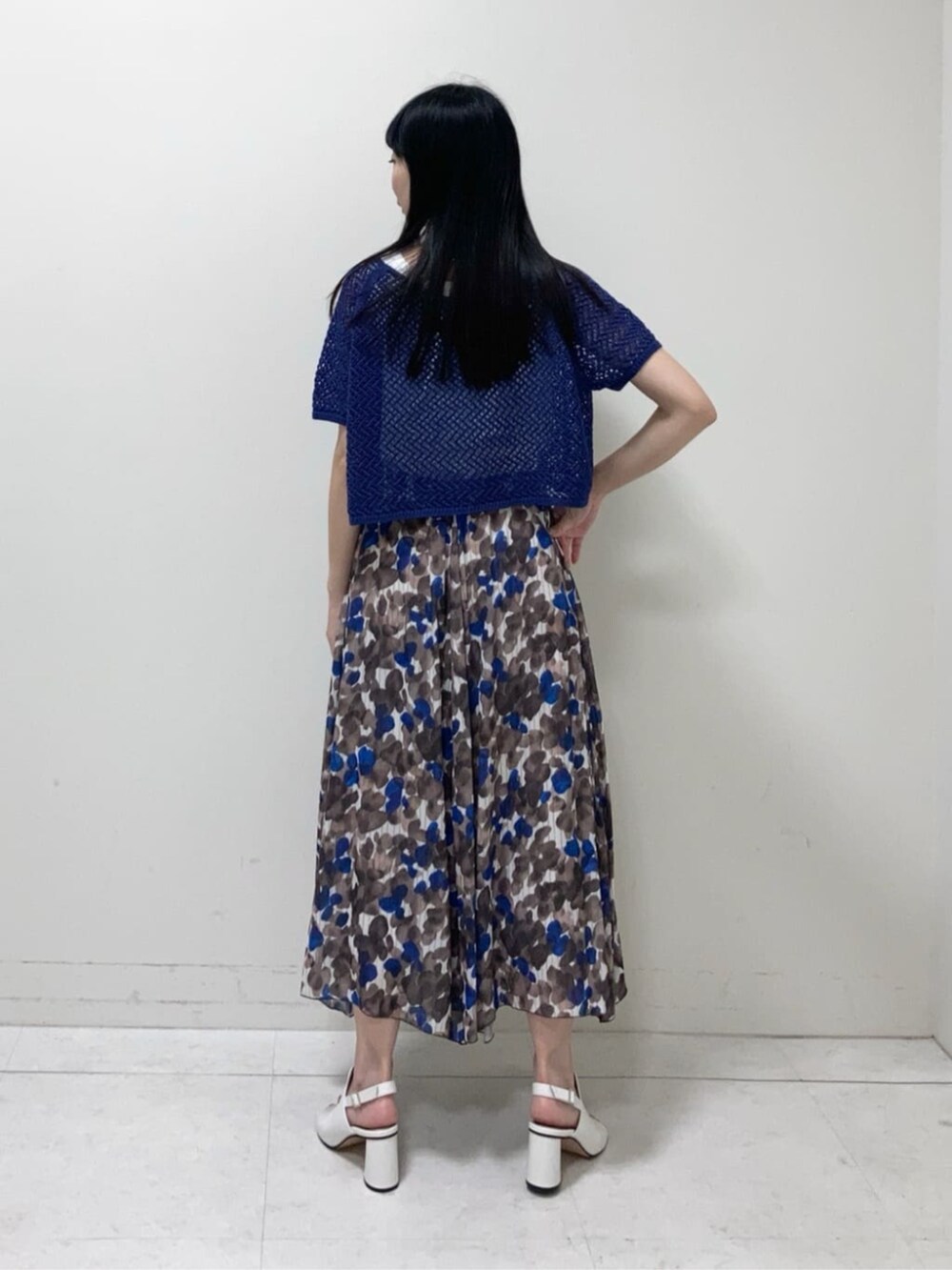 ホワイト系のサンダル、ブラウン系のスカート、ブルー系のアンサンブルを着用したレディースの夏コーディネートの4枚目の写真