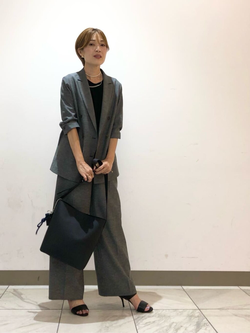 グレー系のテーラードジャケット、グレー系のその他パンツ、ブラック系のシャツ/ブラウスを着用したレディースの秋コーディネートの2枚目の写真