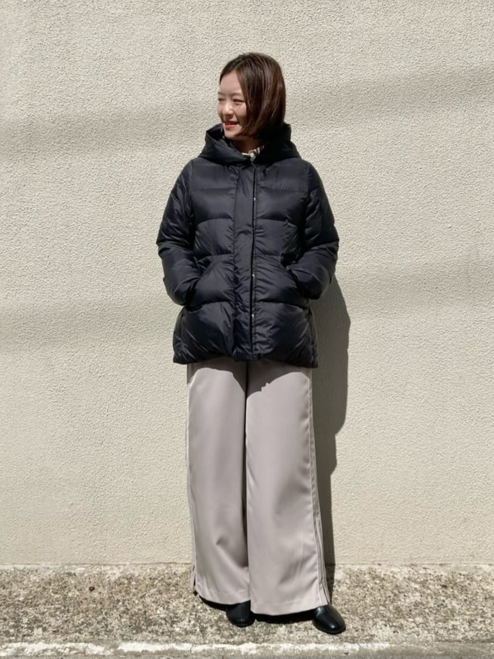 ブラック系のダウンジャケット/コート、ベージュ系のその他パンツ、グレー系のTシャツ/カットソーを着用したレディースの冬コーディネートの6枚目の写真
