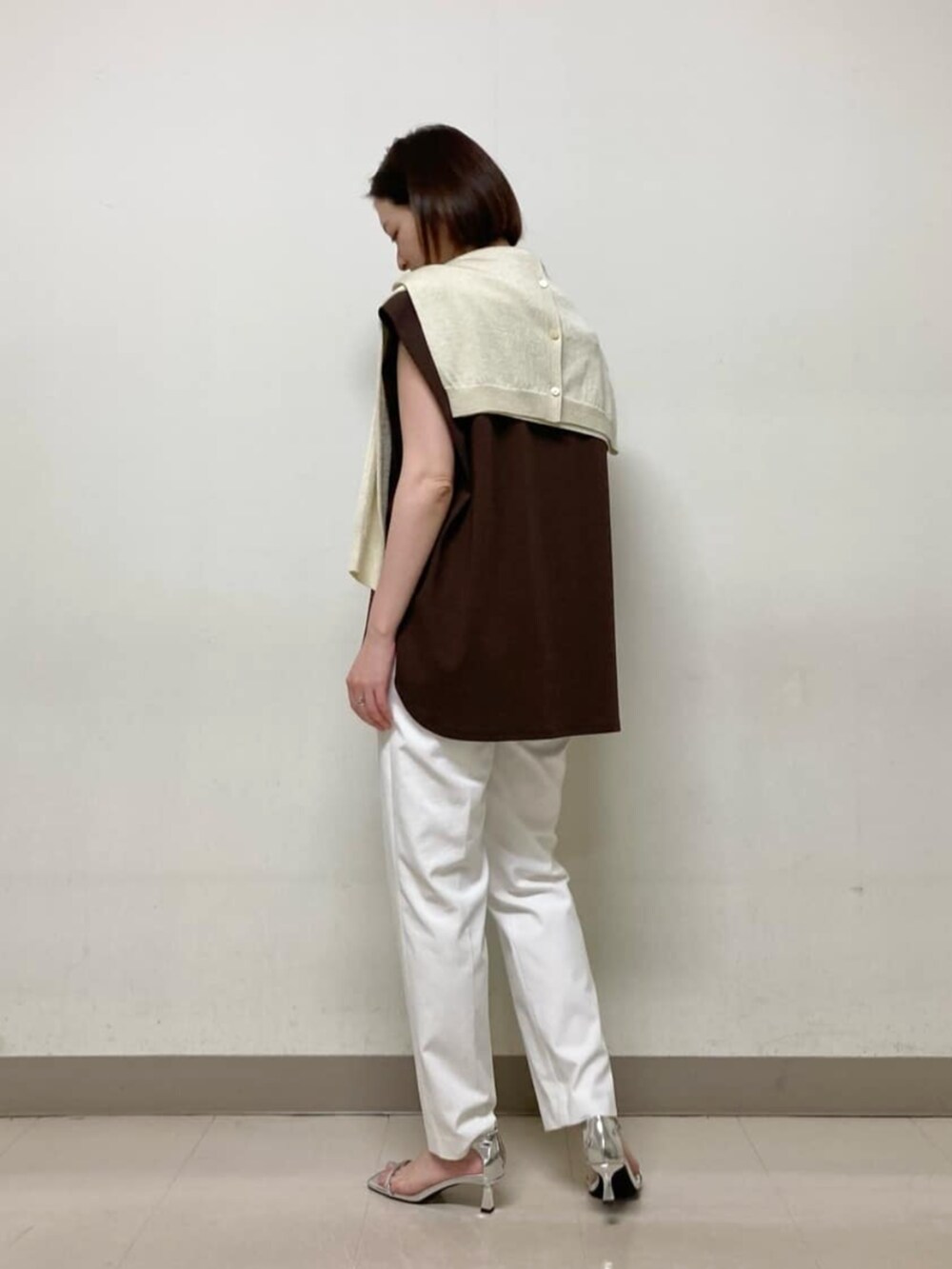 イエロー系のカーディガン/ボレロ、ブラウン系のTシャツ/カットソー、ホワイト系のパンツを着用したレディースの春コーディネートの6枚目の写真