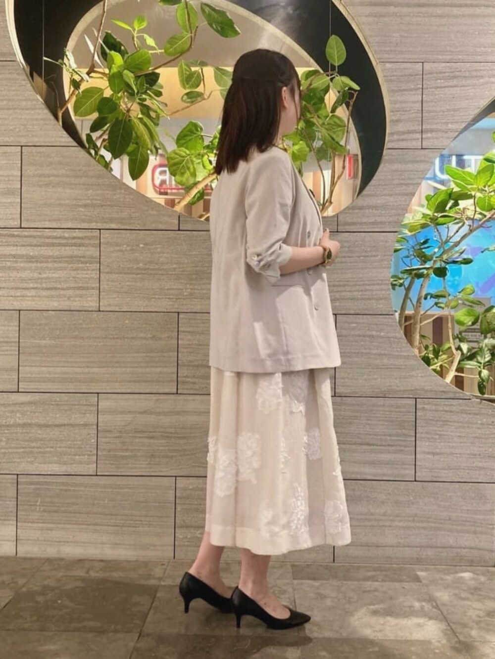 ベージュ系のテーラードジャケット、ベージュ系のワンピース、ホワイト系のネックレスを着用したレディースの夏コーディネートの2枚目の写真