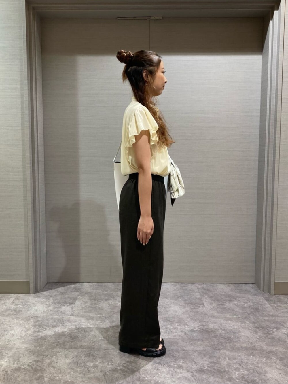 ホワイト系のショルダーバッグ、イエロー系のシャツ/ブラウス、ブラウン系のその他パンツを着用したレディースの夏コーディネートの2枚目の写真