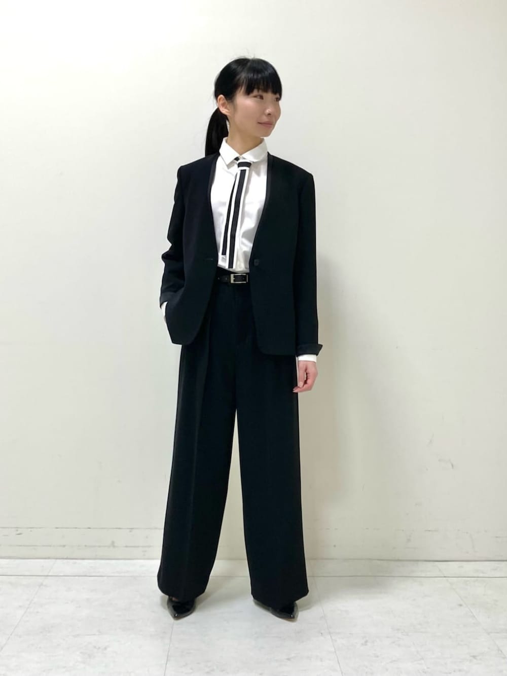 ブラック系のノーカラージャケット、ブラック系のその他パンツ、ホワイト系のシャツ/ブラウスを着用したレディースの夏コーディネートの2枚目の写真