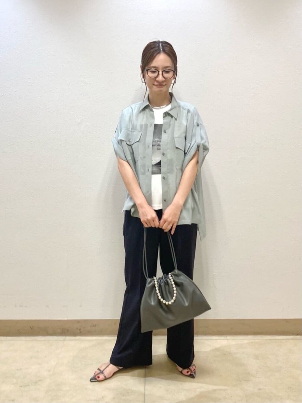 グレー系のシャツ/ブラウス、ブルー系のその他パンツ、グレー系のクラッチバッグを着用したレディースの夏コーディネートの3枚目の写真