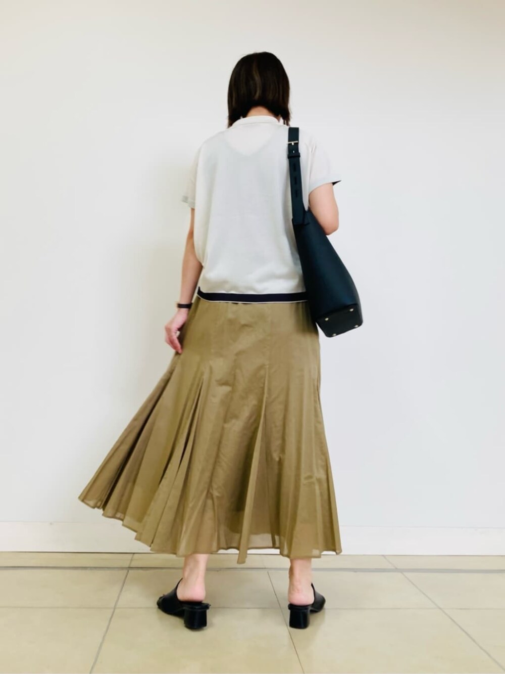 ホワイト系のニット/セーター、イエロー系のスカートを着用したレディースの夏コーディネートの3枚目の写真