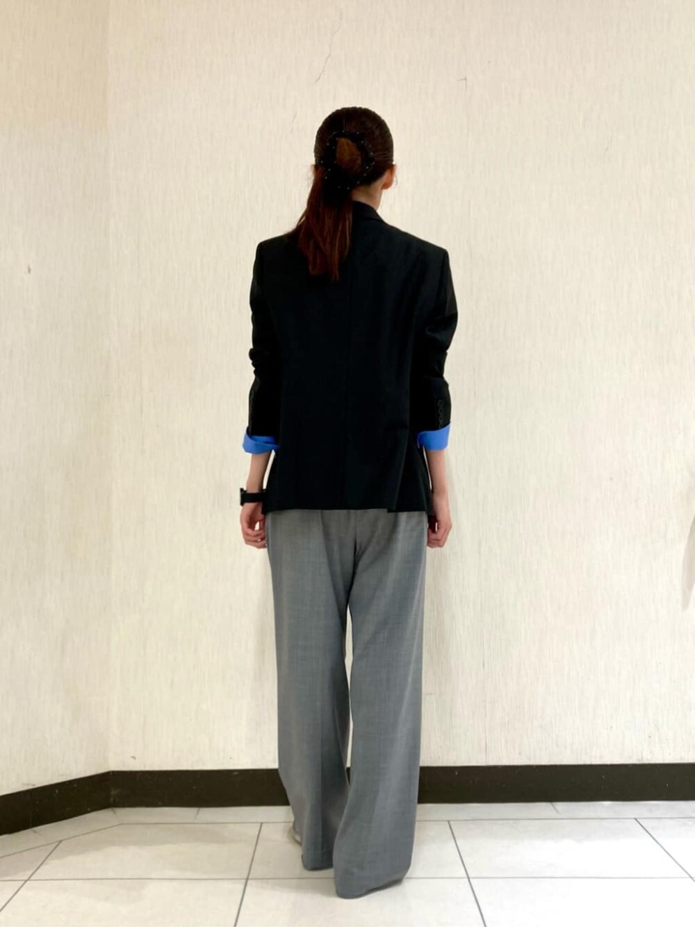 ブルー系のシャツ/ブラウス、グレー系のスーツパンツ、ブラック系のスーツジャケットを着用したレディースの秋コーディネートの3枚目の写真