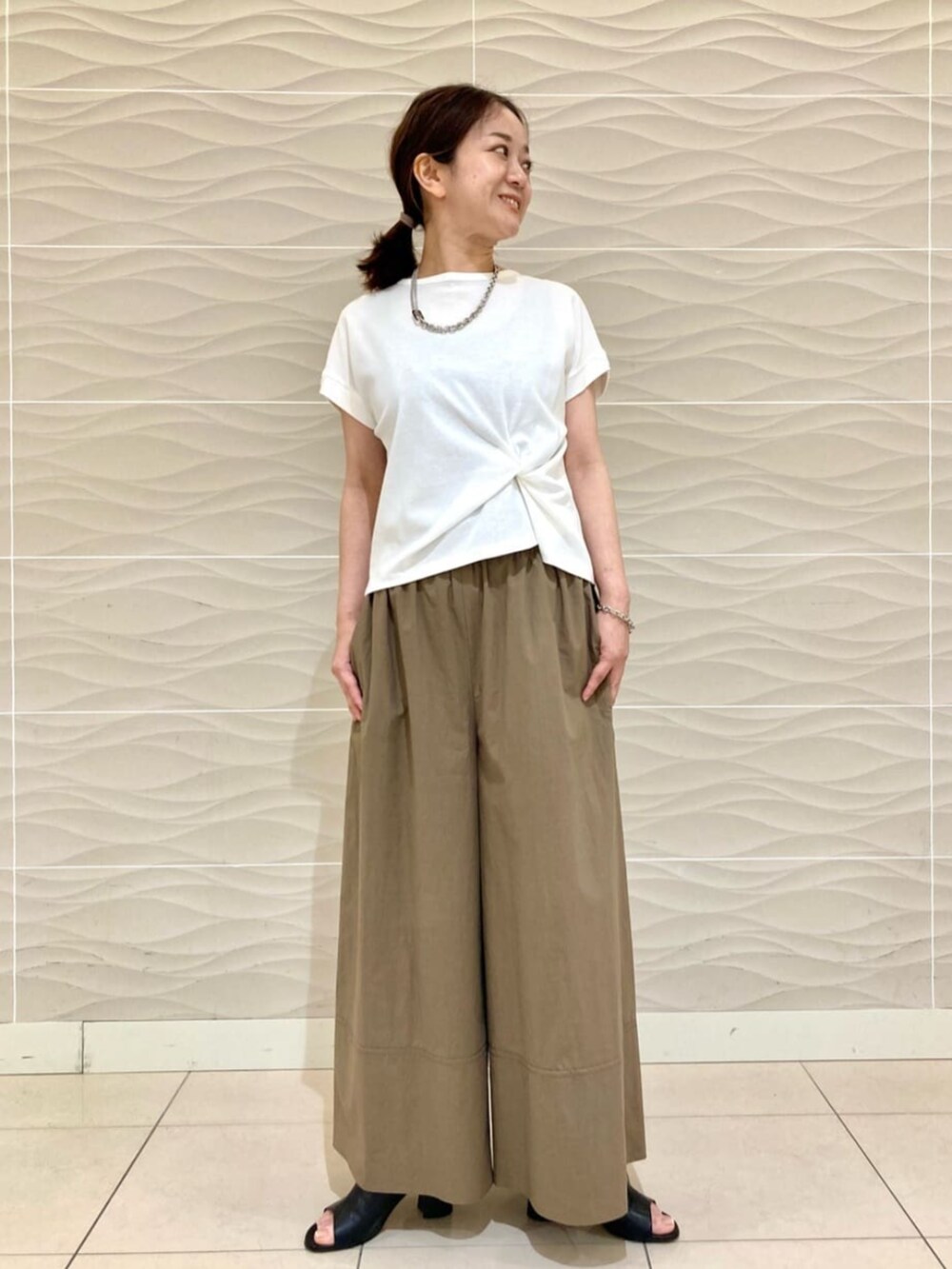 ホワイト系のTシャツ/カットソー、イエロー系のその他パンツ、ホワイト系のブルゾンを着用したレディースの夏コーディネートの2枚目の写真