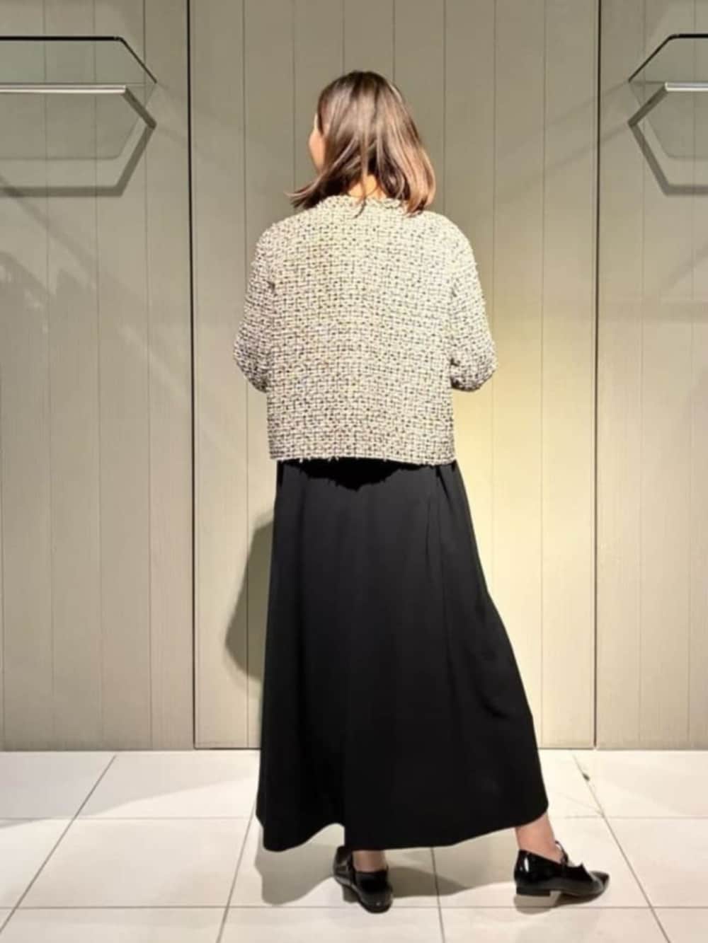 ベージュ系のノーカラージャケット、ブラック系のワンピース、ブラック系のパンプスを着用したレディースの冬コーディネートの4枚目の写真