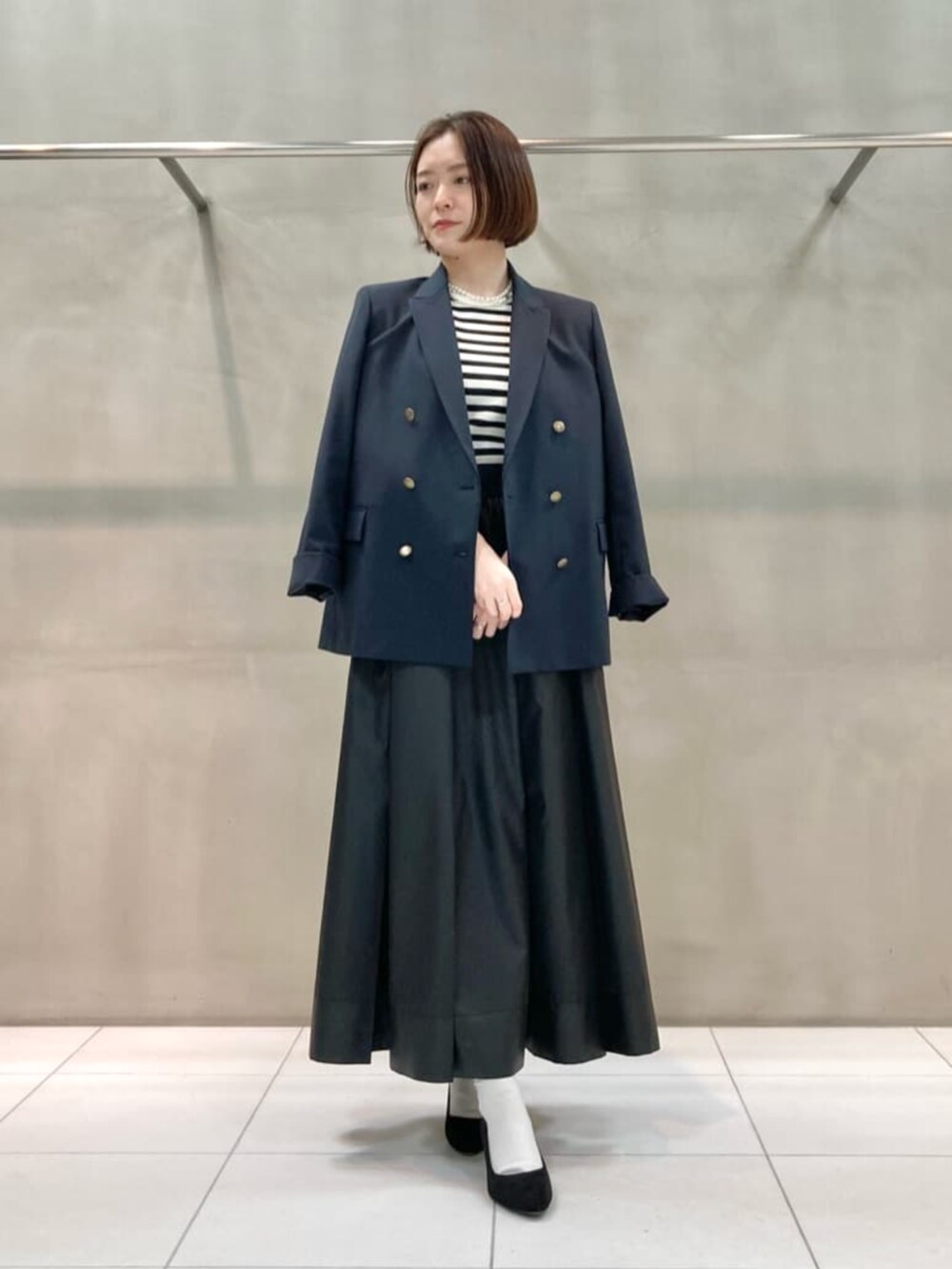 ブルー系のセットアップ、ホワイト系のニット/セーター、ブラック系のスカートを着用したレディースの春コーディネートの6枚目の写真