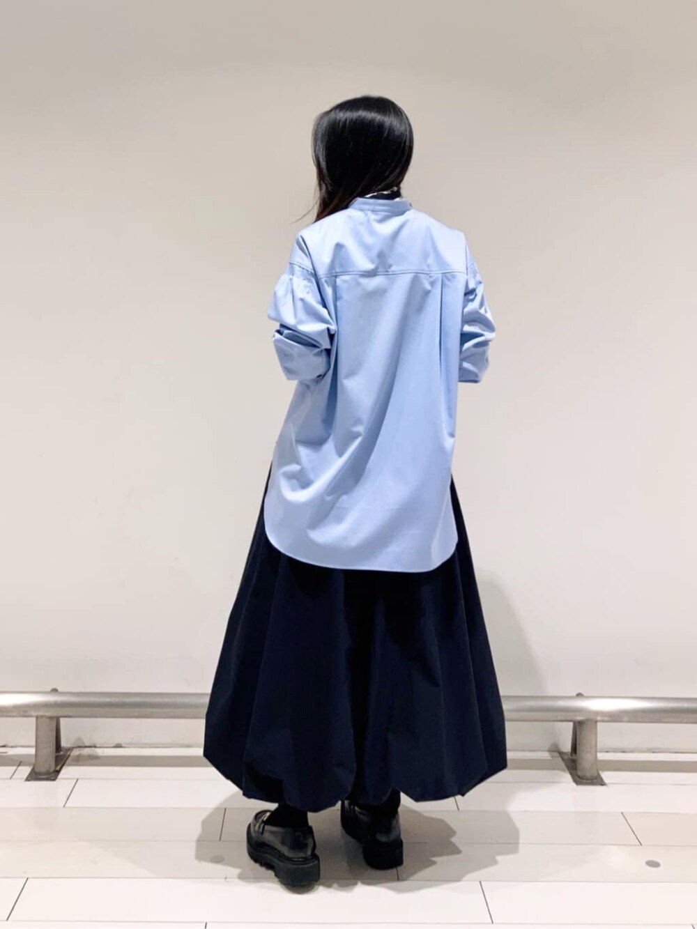 ブラック系のスカート、ブルー系のシャツ/ブラウス、ブラック系のストール/ショールを着用したレディースの春コーディネートの4枚目の写真