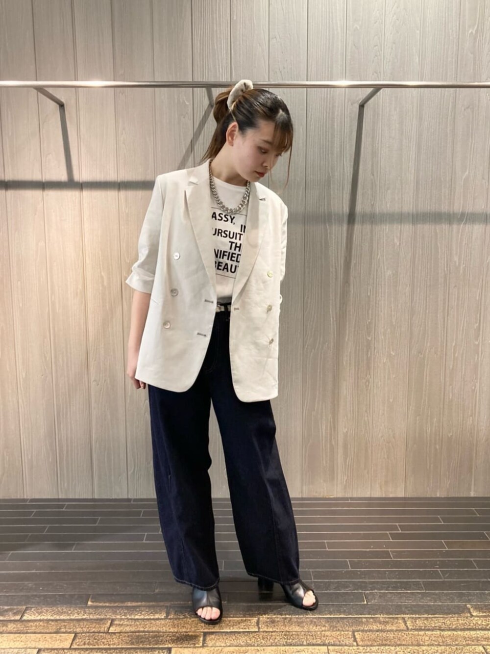 ホワイト系のTシャツ/カットソー、ブラック系のサンダル、ブルー系のデニムパンツを着用したレディースの夏コーディネートの3枚目の写真