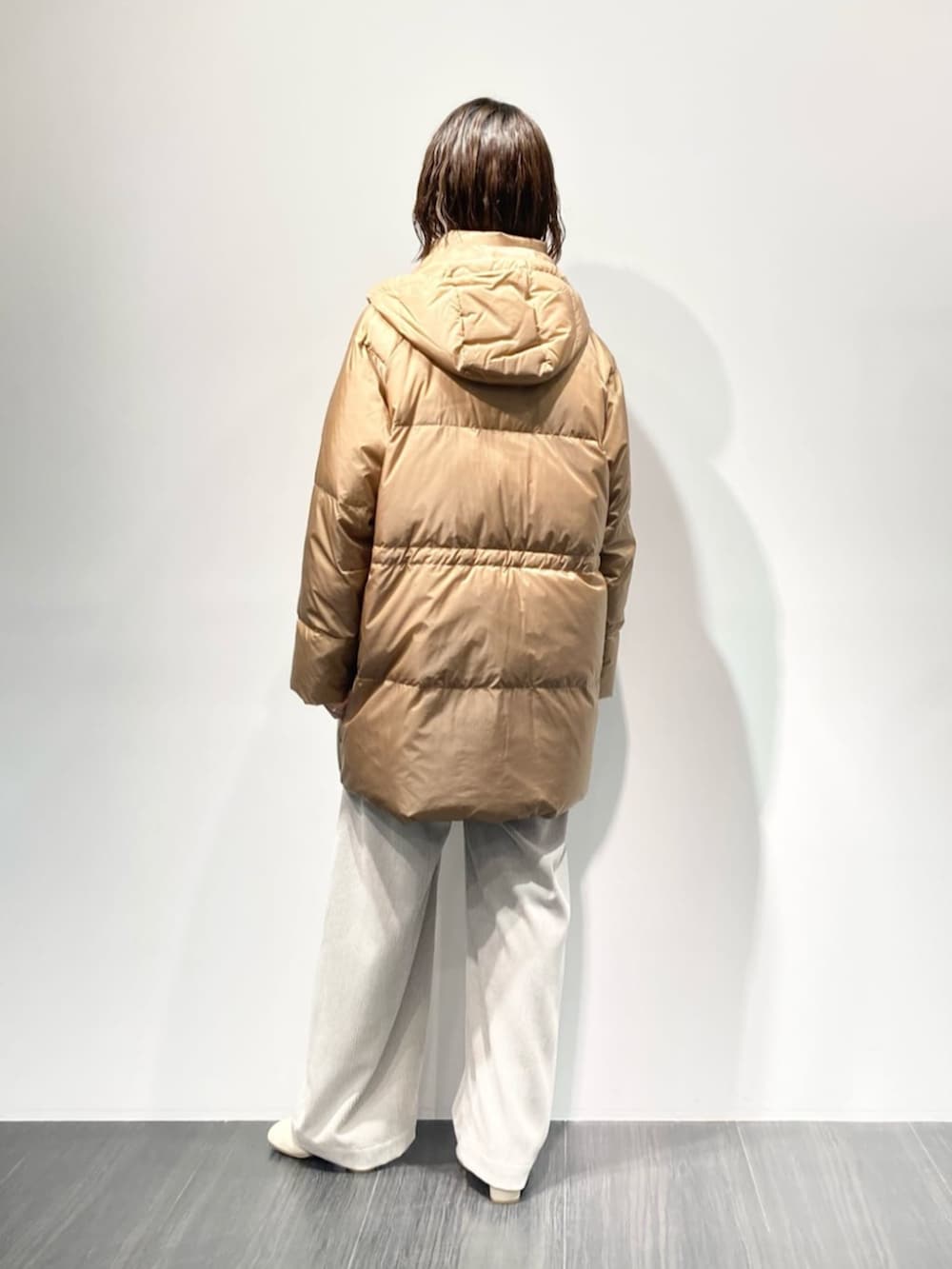 イエロー系のダウンジャケット/コート、ベージュ系のその他パンツ、ホワイト系のブーツを着用したレディースの秋コーディネートの5枚目の写真