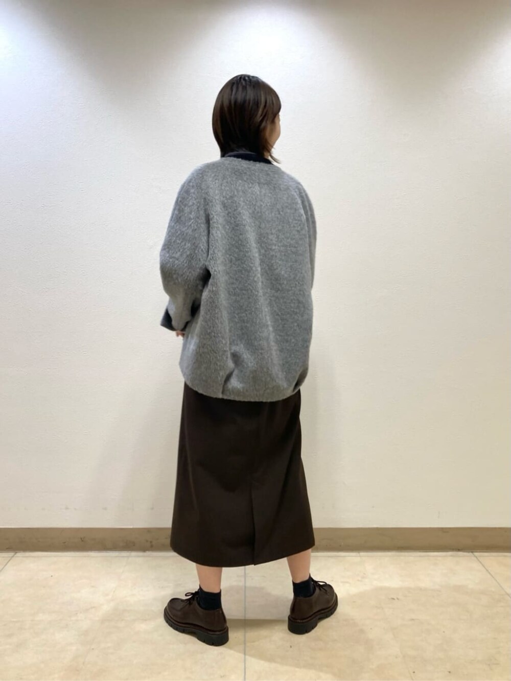 グレー系のその他アウター、ブラック系のスカートを着用したレディースの冬コーディネートの3枚目の写真