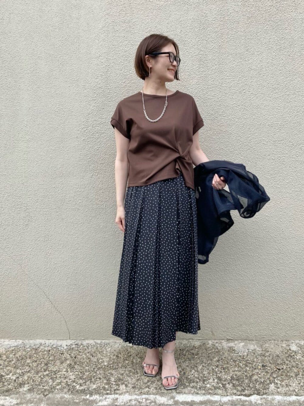 ブラウン系のTシャツ/カットソー、ホワイト系のスカート、ブルー系のブルゾンを着用したレディースの夏コーディネートの2枚目の写真