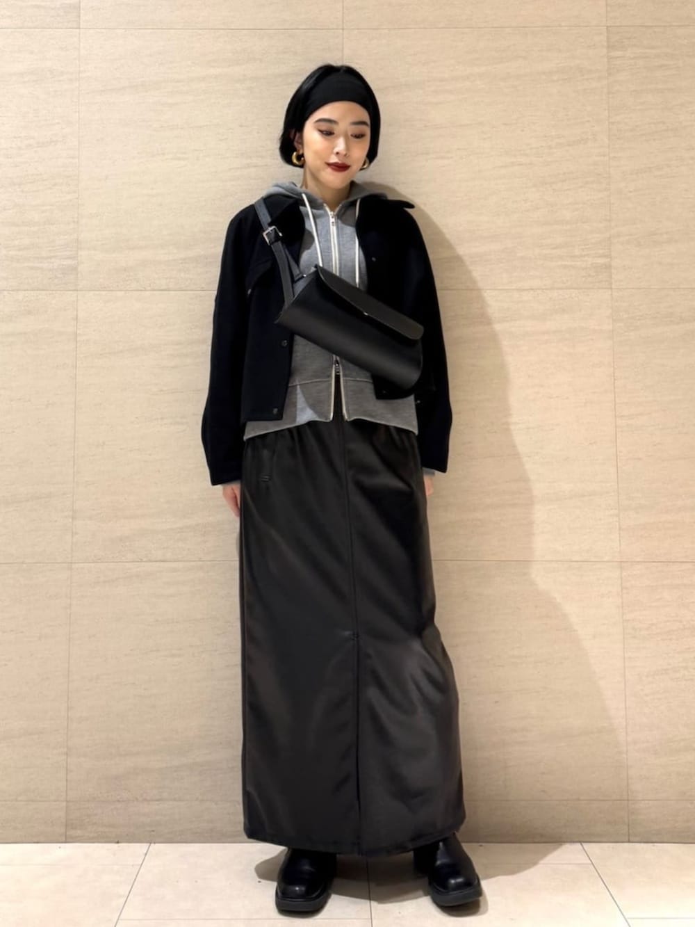 ブラック系のスカート、ブラック系のショルダーバッグ、ブラック系のブルゾンを着用したレディースの冬コーディネートの3枚目の写真