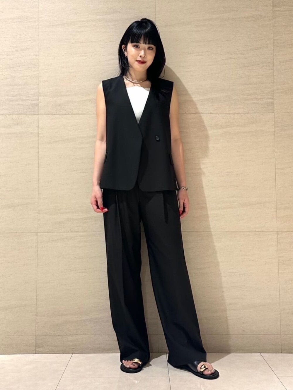 ブラック系のベスト、ホワイト系のキャミソール、ブラック系のその他パンツを着用したレディースの夏コーディネートの3枚目の写真