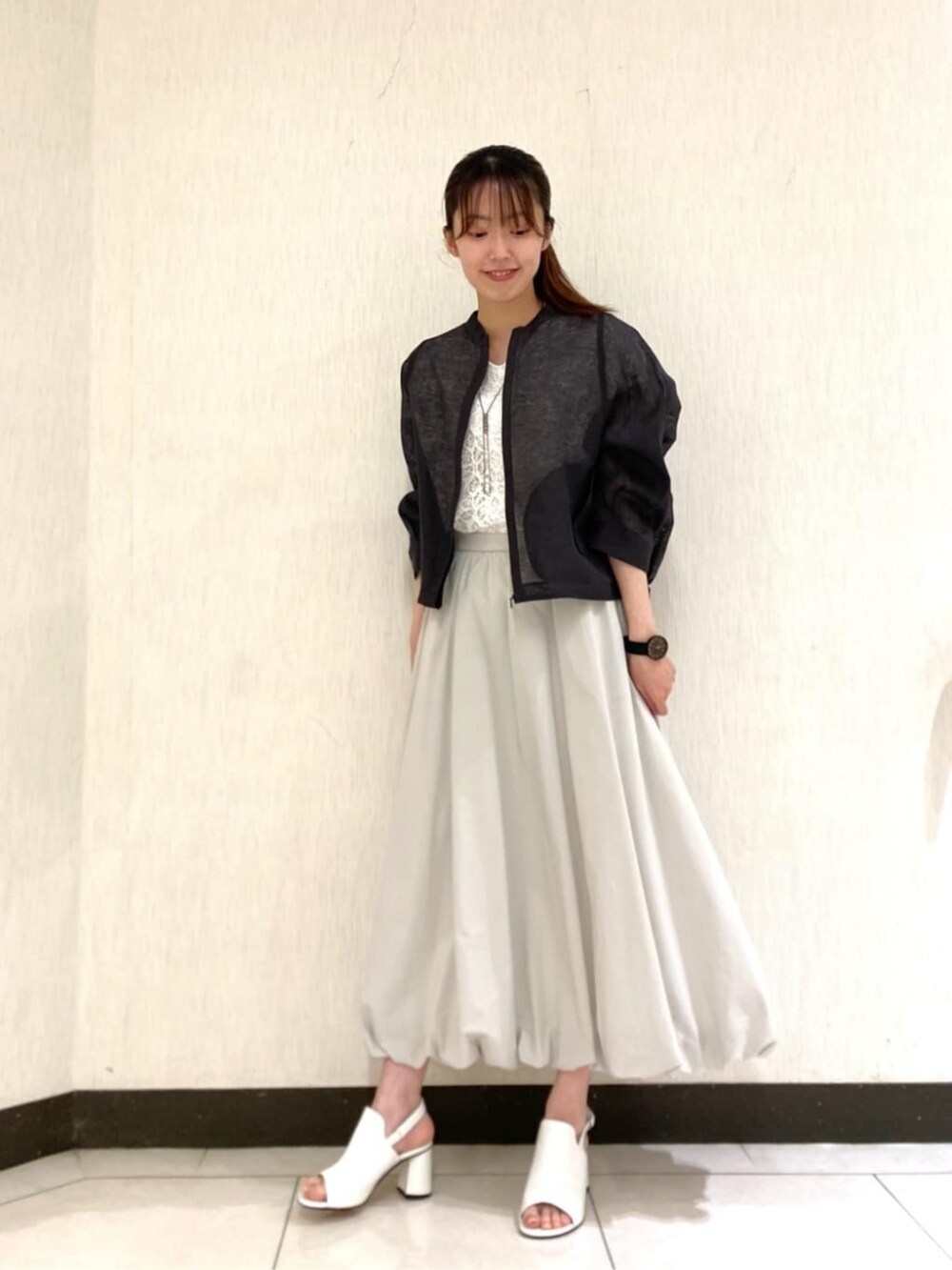 ホワイト系のサンダル、ホワイト系のシャツ/ブラウス、グレー系のスカートを着用したレディースの夏コーディネートの2枚目の写真