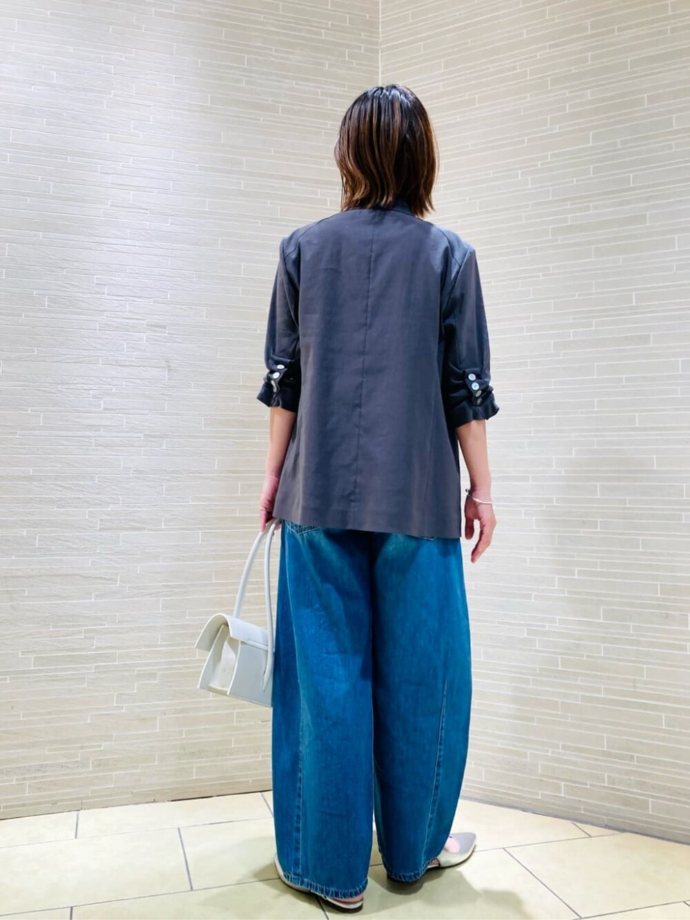 ホワイト系のTシャツ/カットソー、グレー系のテーラードジャケット、ブルー系のデニムパンツを着用したレディースの春コーディネートの4枚目の写真